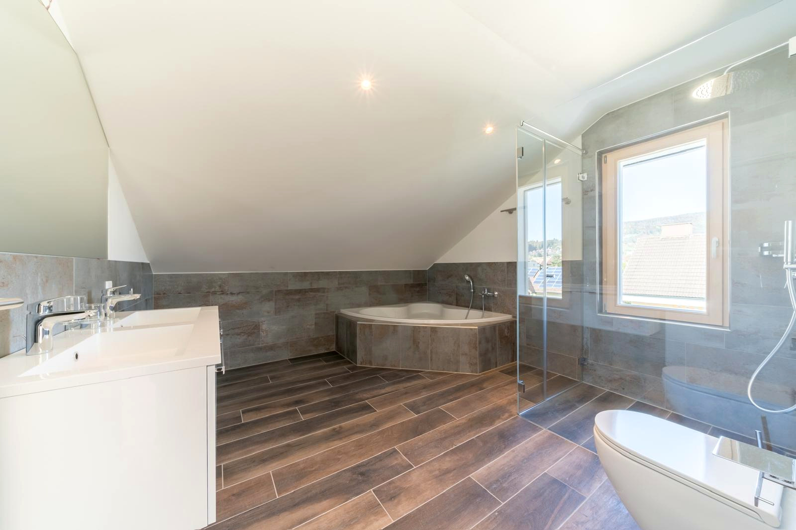 Grosszügiges Badezimmer mit Badewanne und Dusche nach der Totalsanierung
